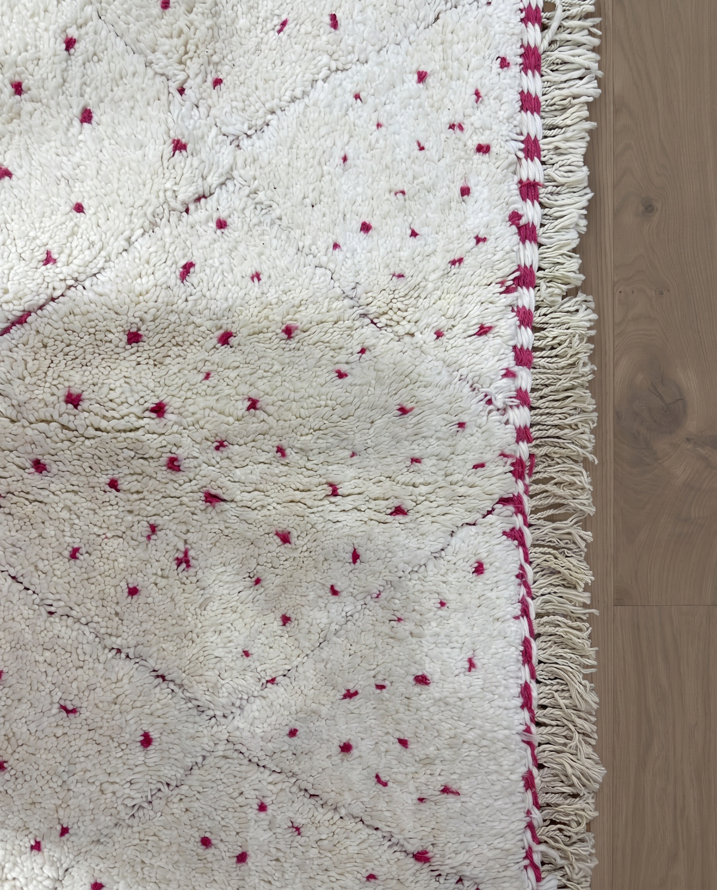 ZULEIKHA Beni Ourain cream dotted diamond lattice Moroccan rug close-up of hand-tied fringe and kilim band detail, by NURA